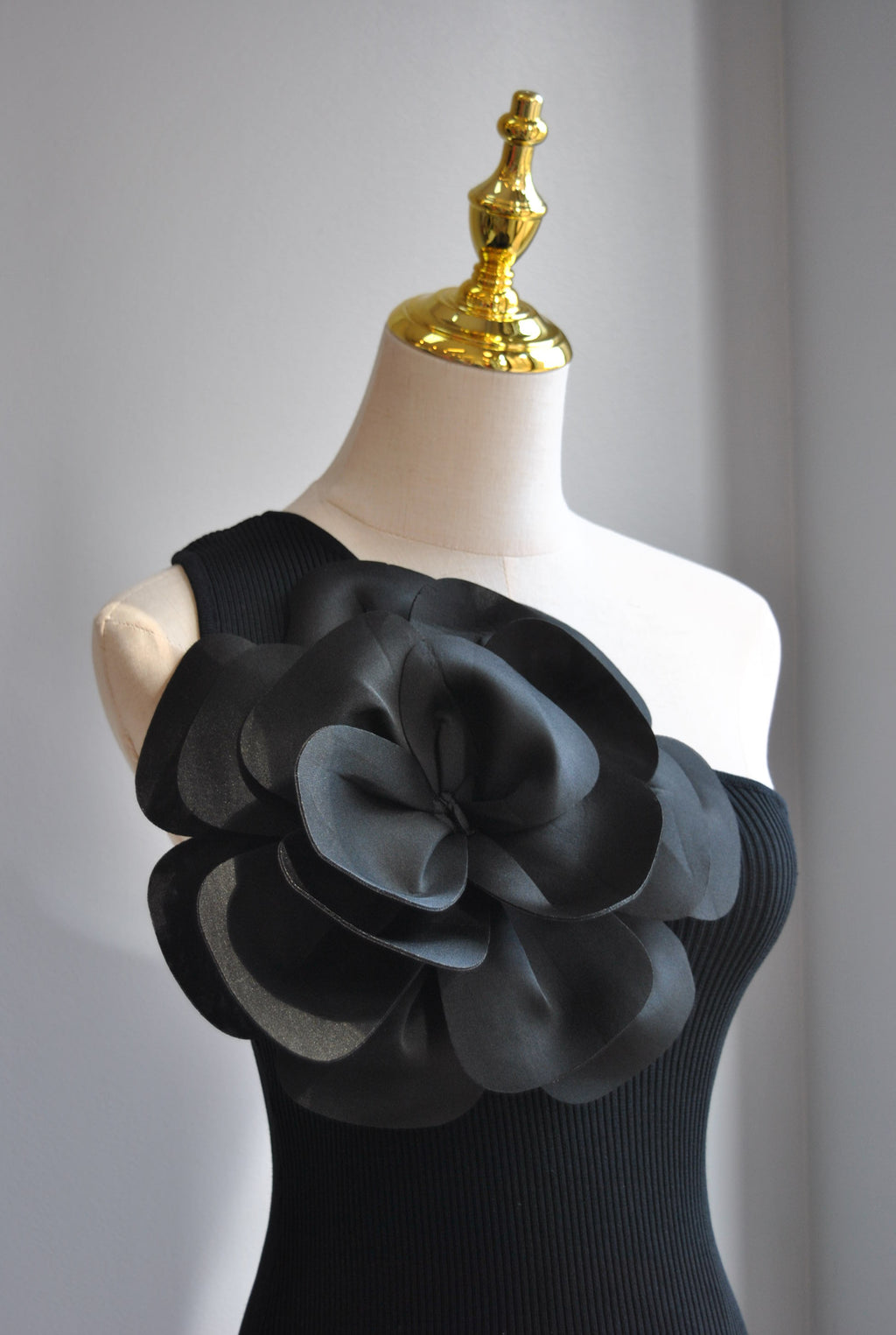 BLACK ASYMMETRIC TOP WITH A FLOWER
