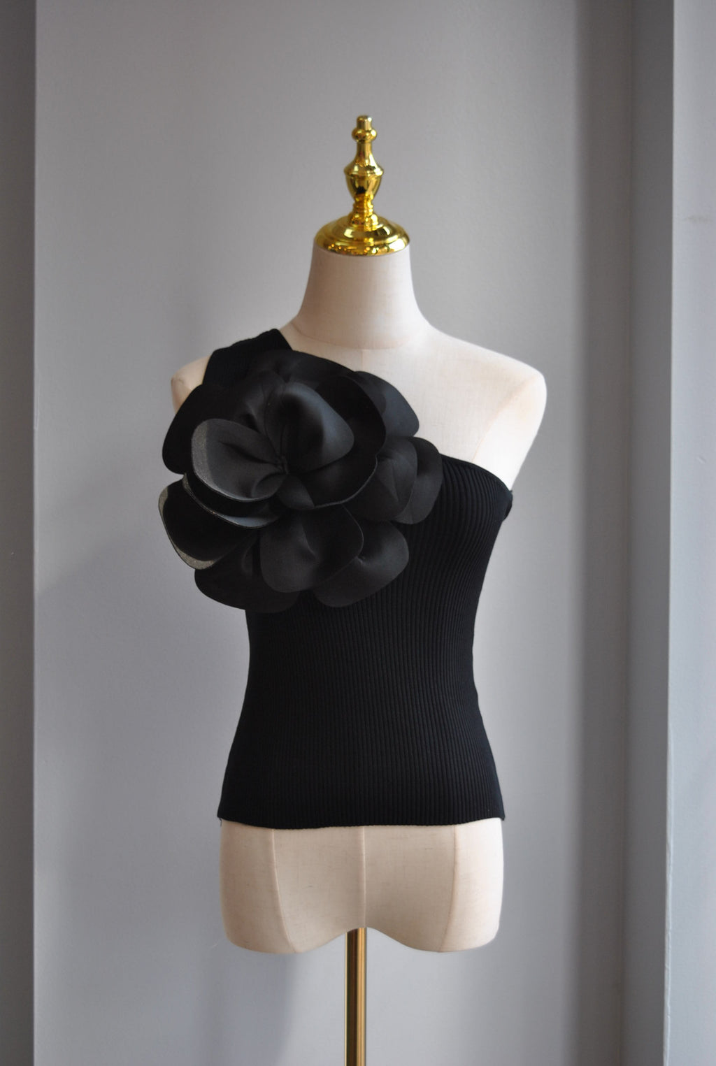 BLACK ASYMMETRIC TOP WITH A FLOWER