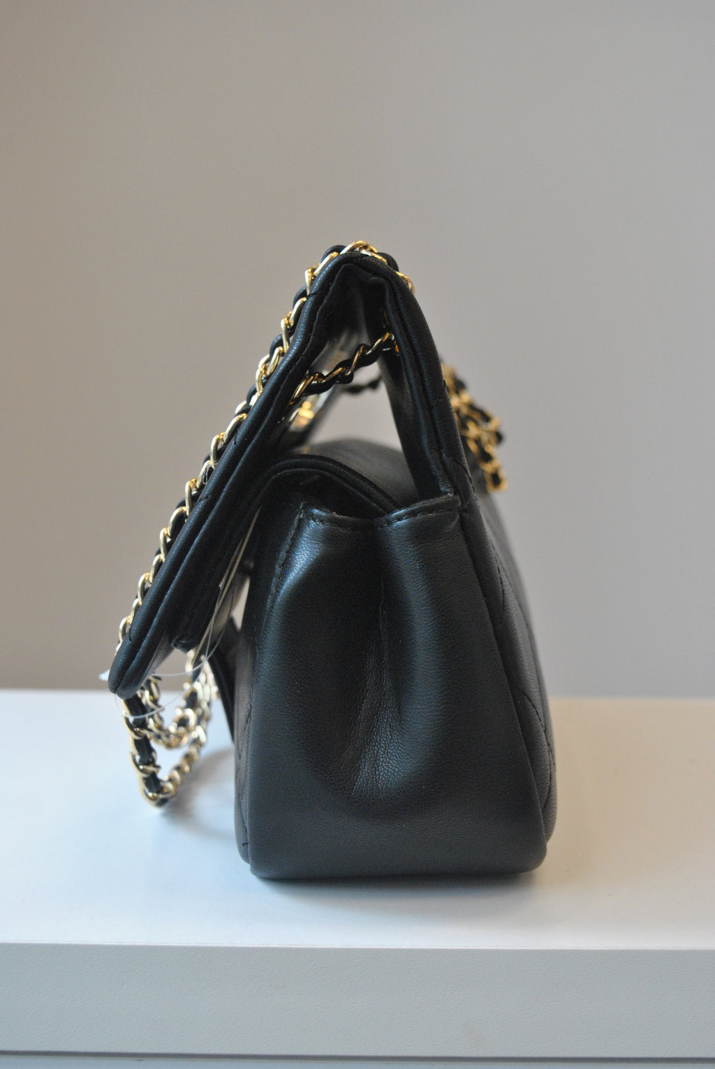 BLACK GUILTED HANDBAG WITH CUTOFF  HANDLE AND GOLD CHAIN